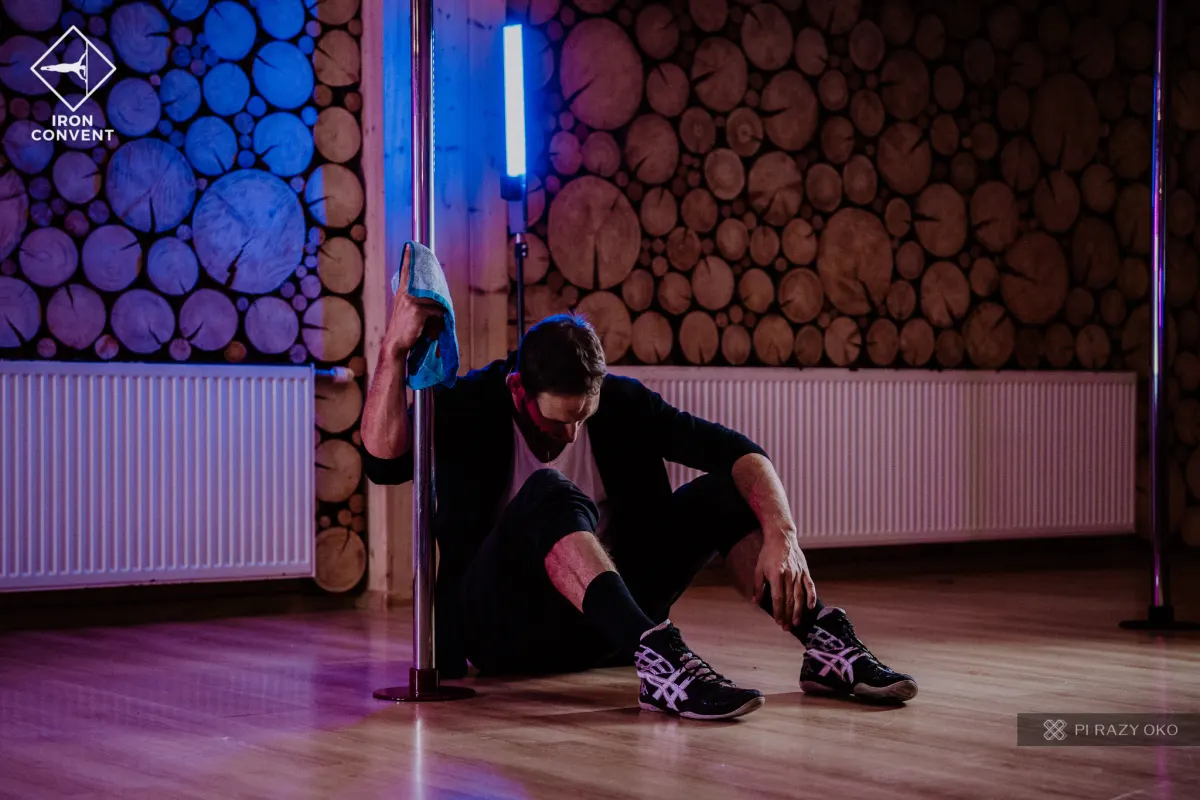 Tancerz podczas choreografii na podłodze przy rurce